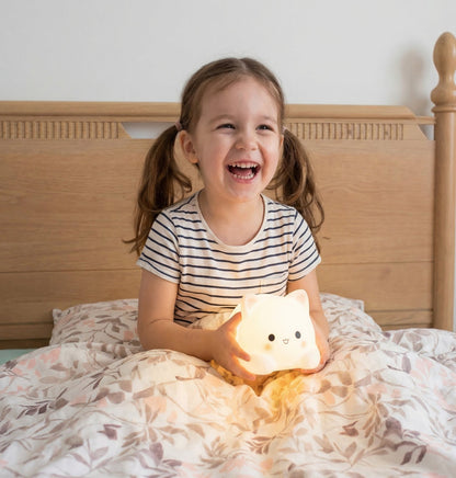 Child holding glowing cat night light for kids bedtime comfort